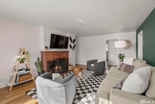 living room featuring a brick fireplace and hardwood / wood-style floors