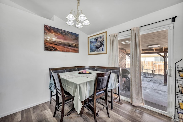 dining space featuring vaulted ceiling, hardwood / wood-style floors, and a chandelier