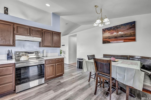 kitchen with decorative light fixtures, lofted ceiling, light hardwood / wood-style floors, an inviting chandelier, and electric stove