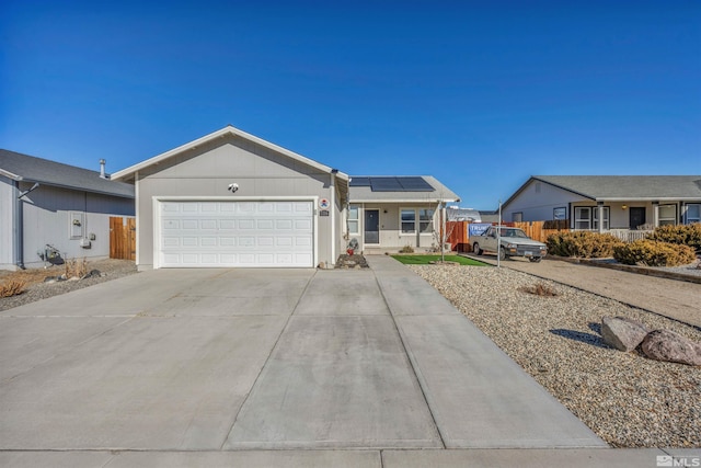 ranch-style home with a garage and solar panels