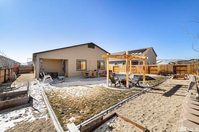 rear view of property featuring a pergola and a patio area