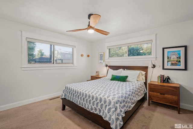 bedroom with multiple windows, light carpet, and ceiling fan