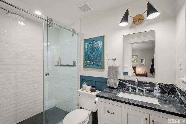 bathroom featuring walk in shower, vanity, and toilet