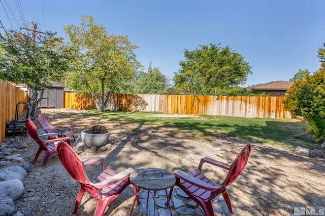 view of patio / terrace with a storage shed and an outdoor fire pit