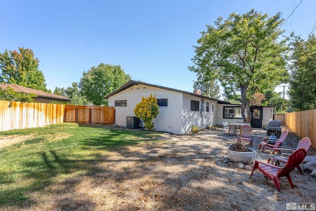 back of property featuring a yard and a fire pit