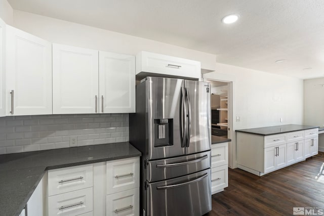 kitchen with stainless steel refrigerator with ice dispenser, white cabinetry, dark hardwood / wood-style flooring, and decorative backsplash