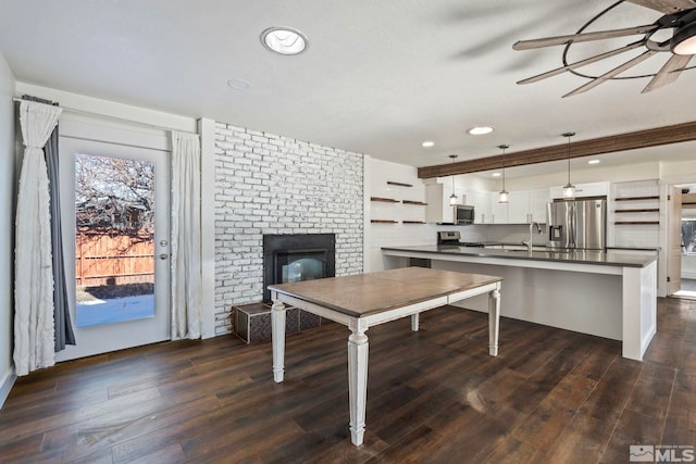 kitchen featuring hanging light fixtures, white cabinetry, dark hardwood / wood-style flooring, and stainless steel appliances