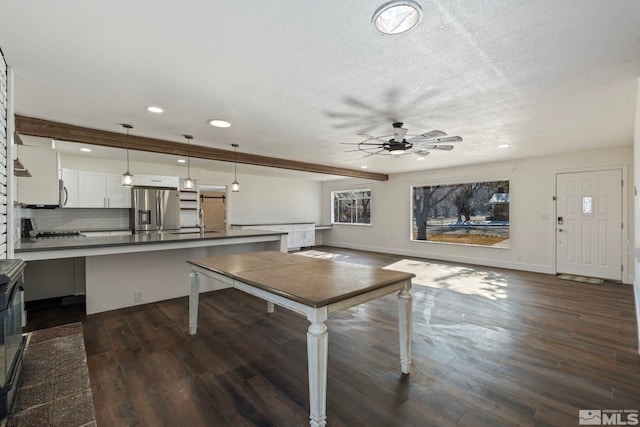 unfurnished dining area featuring ceiling fan, dark hardwood / wood-style floors, and a textured ceiling