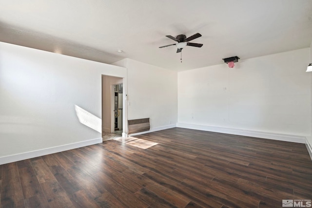 empty room featuring radiator heating unit, dark hardwood / wood-style floors, and ceiling fan