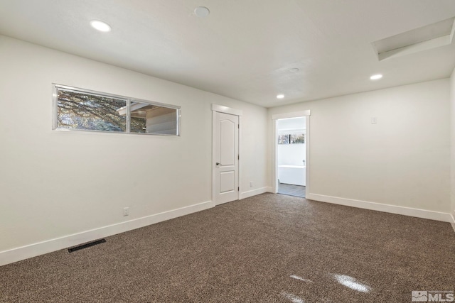 spare room with dark colored carpet