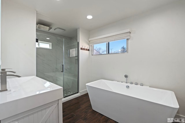 bathroom with hardwood / wood-style flooring, vanity, plus walk in shower, and a wealth of natural light