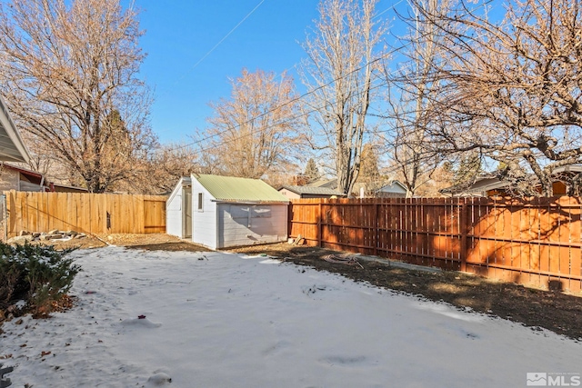 snowy yard featuring a shed