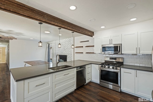 kitchen featuring sink, appliances with stainless steel finishes, kitchen peninsula, pendant lighting, and white cabinets