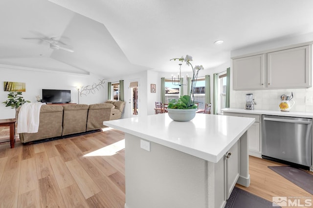 kitchen with lofted ceiling, dishwasher, white cabinets, a kitchen island, and light wood-type flooring