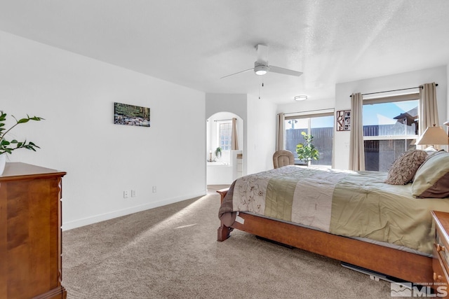 bedroom with ensuite bath, a textured ceiling, access to outside, carpet floors, and ceiling fan