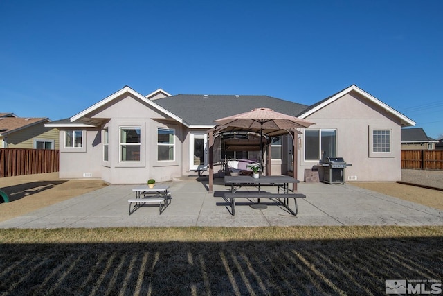 back of property featuring a gazebo, a patio, and a lawn