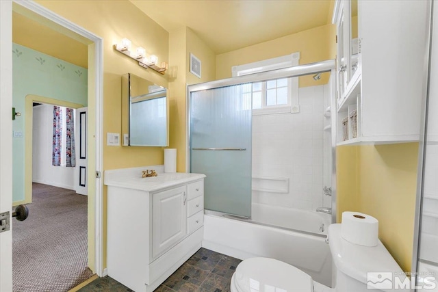 full bathroom featuring enclosed tub / shower combo, vanity, and toilet