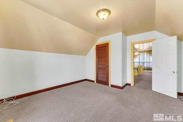 additional living space with carpet flooring and vaulted ceiling