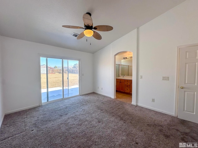 carpeted spare room featuring lofted ceiling, sink, and ceiling fan