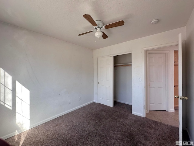 unfurnished bedroom with ceiling fan, light colored carpet, a closet, and a textured ceiling