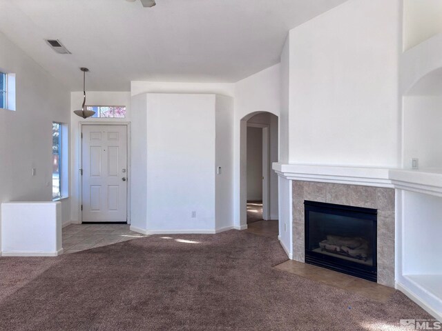 unfurnished living room with light carpet and a fireplace