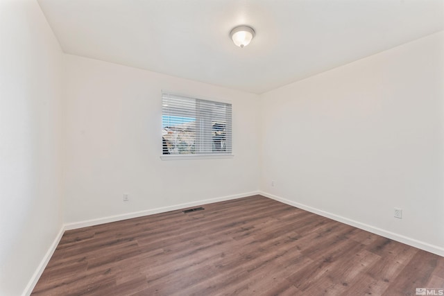 unfurnished room with dark hardwood / wood-style flooring