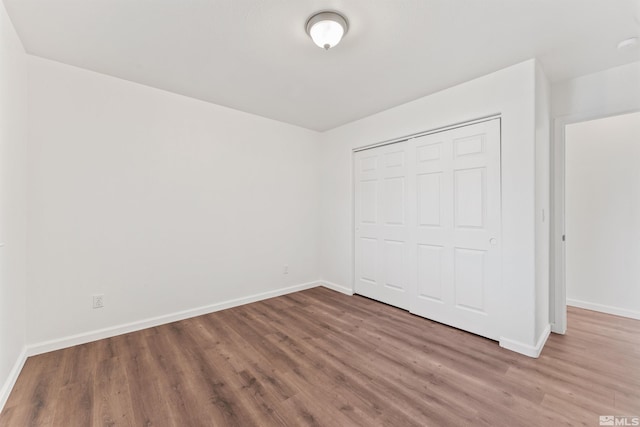 unfurnished bedroom with hardwood / wood-style flooring and a closet