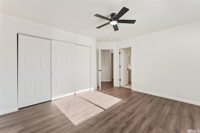 unfurnished bedroom featuring dark wood-type flooring, a closet, and ceiling fan