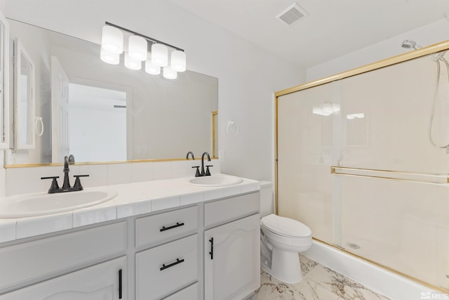 bathroom featuring vanity, a shower with shower door, and toilet