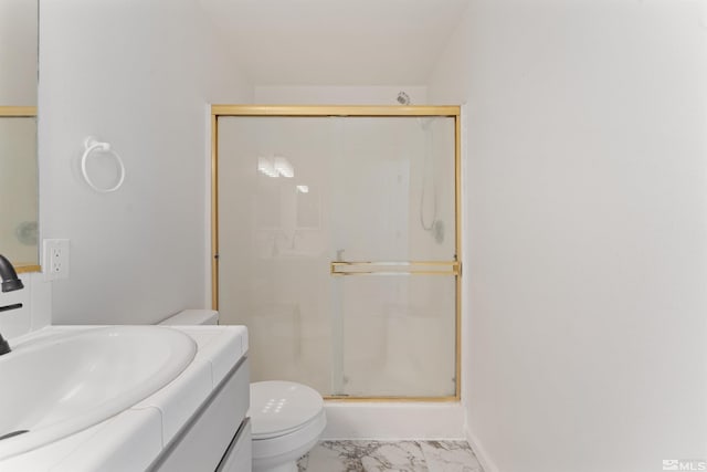 bathroom featuring a shower with door, vanity, and toilet