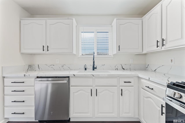 kitchen featuring light stone countertops, white cabinetry, appliances with stainless steel finishes, and sink