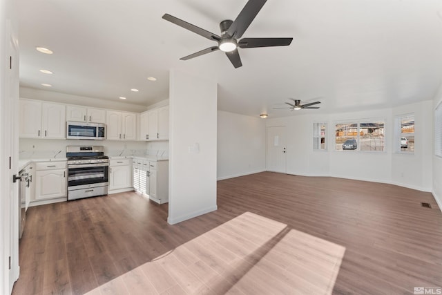 kitchen featuring dark wood-type flooring, stainless steel appliances, and white cabinets