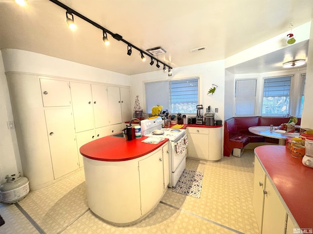 kitchen with white cabinetry, sink, and electric stove