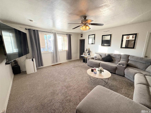 living room featuring ceiling fan, carpet flooring, and a textured ceiling