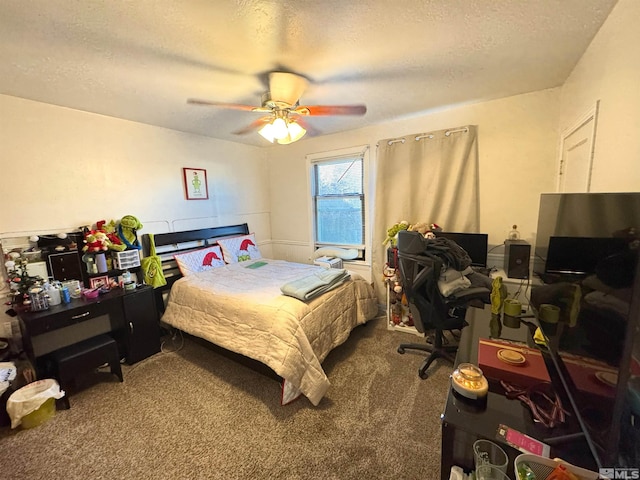 bedroom with ceiling fan, carpet floors, and a textured ceiling