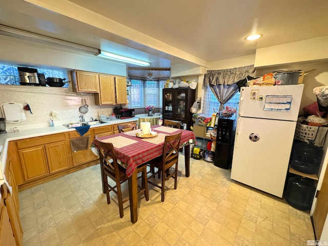 kitchen featuring white refrigerator, sink, and tasteful backsplash