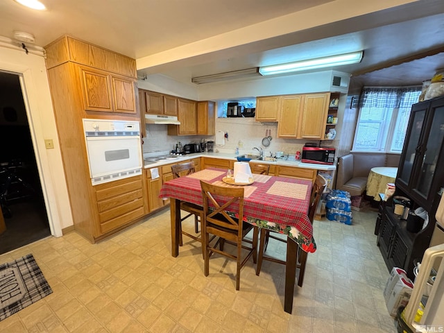 kitchen with white appliances, sink, and backsplash