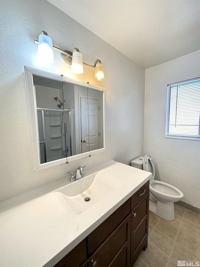 bathroom with vanity, a shower with shower door, and toilet