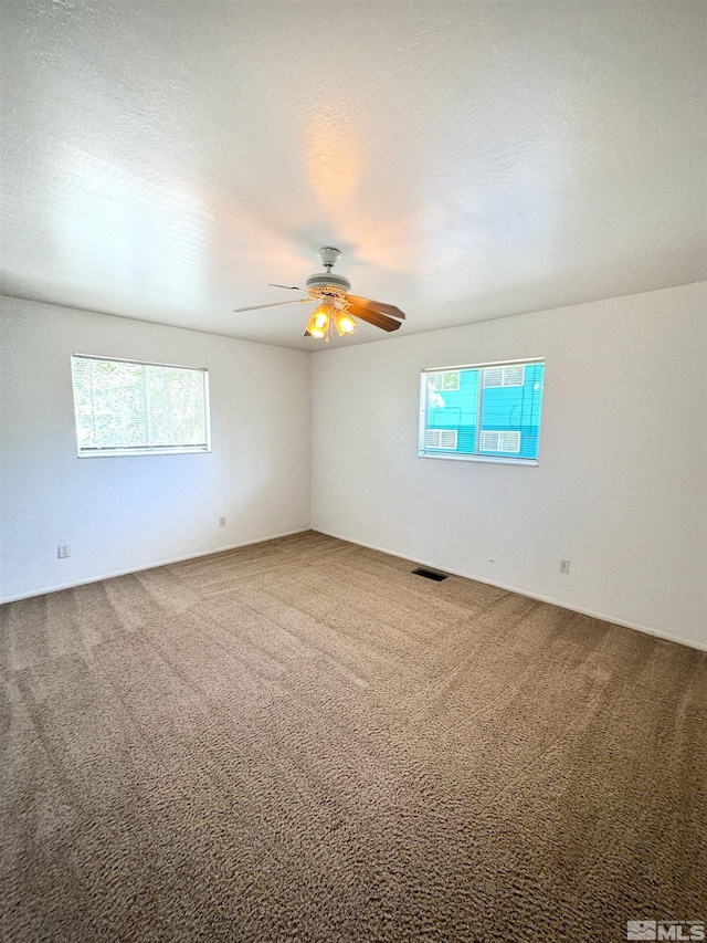 unfurnished room featuring a textured ceiling, ceiling fan, and carpet flooring