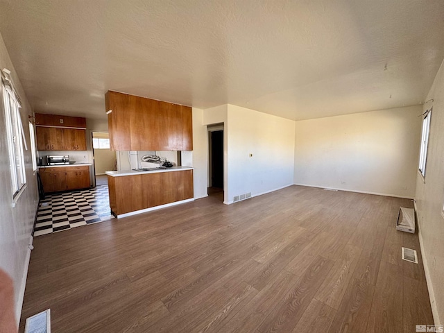 unfurnished living room with wood-type flooring and a textured ceiling