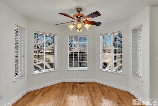 spare room with ceiling fan and light wood-type flooring