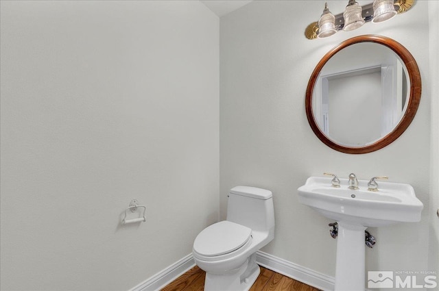 bathroom with hardwood / wood-style floors and toilet