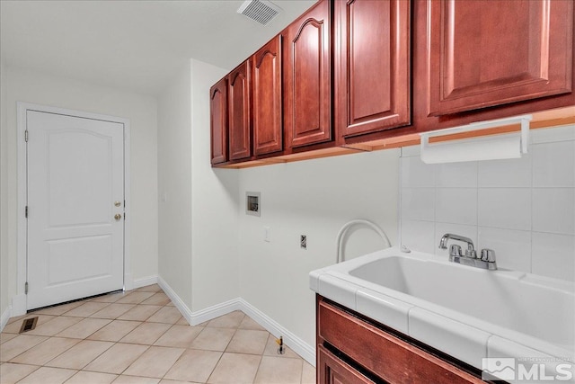 laundry area featuring sink, hookup for a washing machine, cabinets, and light tile patterned flooring