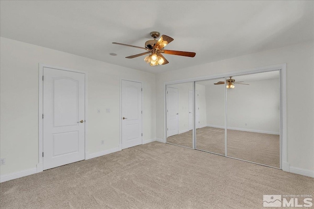 unfurnished bedroom featuring light colored carpet and ceiling fan