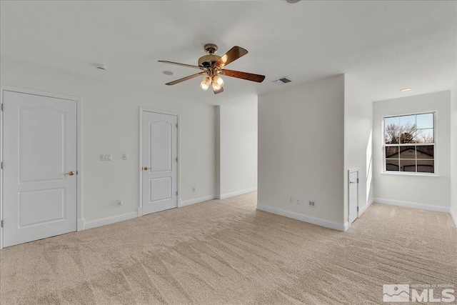 empty room featuring ceiling fan and light colored carpet