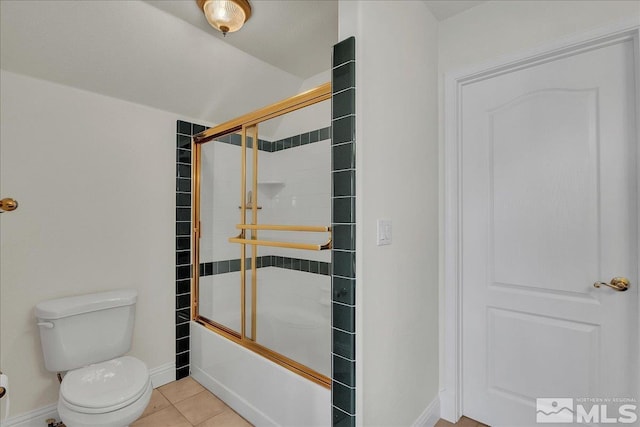 bathroom featuring tile patterned flooring, toilet, and combined bath / shower with glass door