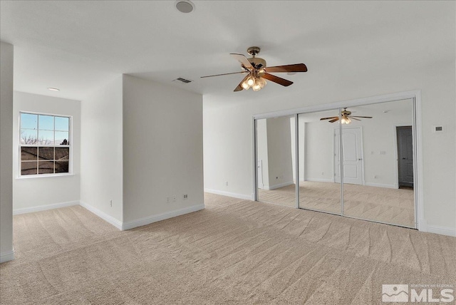 interior space with light carpet and ceiling fan