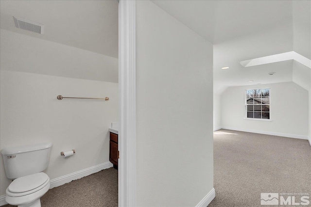 bathroom with vanity, lofted ceiling, and toilet