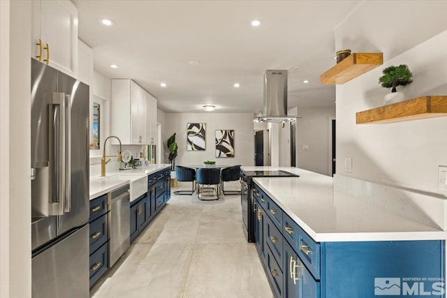 kitchen featuring white cabinetry, island range hood, stainless steel appliances, and blue cabinets