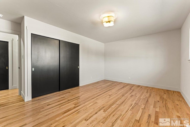 unfurnished bedroom with light hardwood / wood-style floors and a closet